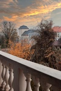 a white balcony with a view of a city at Hegyalja Étterem és Panzió in Zsámbék