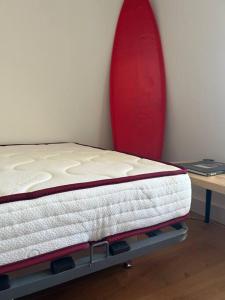 un lit est assis à côté d'un mur avec une planche de surf dans l'établissement Superbe studio port Fréjus 2 - 800m de la plage, à Fréjus