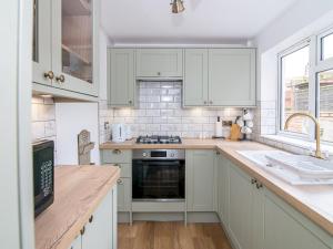 een keuken met witte kasten en een fornuis met oven bij Perfect Home near Cotswolds in Worcester