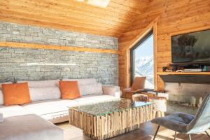 ein Wohnzimmer mit einem Sofa und einem Kamin in der Unterkunft Chalet Lumière - LaGodille Prestige - 16 personnes - Pra Loup in Uvernet