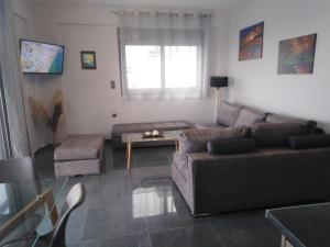 a living room with a couch and a table at Villa George sunrise in Ratzaklíon