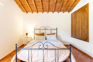 uma cama num quarto com tecto em madeira em Olive House Tuscany em Calci