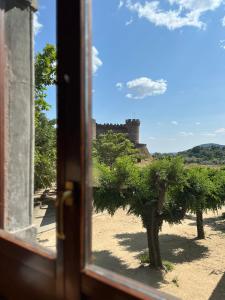 een raam met uitzicht op een kasteel bij Hostal Villa el Colmenar in Mombeltrán