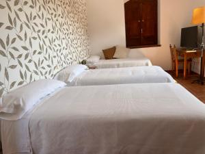 A bed or beds in a room at Hostal Villa el Colmenar