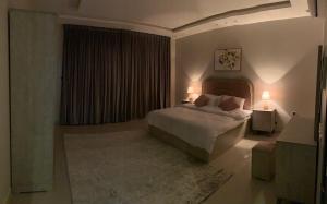 een slaapkamer met een bed met twee lampen erop bij شقق العارض in Riyad