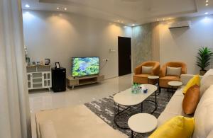 a living room with a couch and a tv at شقق العارض 1 in Riyadh +8 photos