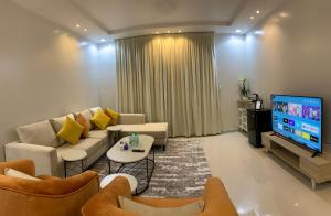 een woonkamer met een bank en een tv bij شقق العارض in Riyad