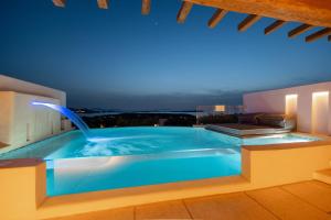 a swimming pool with a water fountain on a building at Anna Platanou Suites in Agia Irini Paros