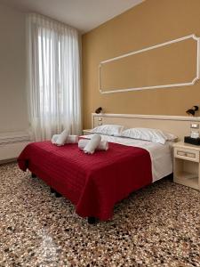 - une chambre avec un grand lit et une couverture rouge dans l'établissement Collegio AMDG, à Venise
