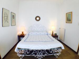 een slaapkamer met een wit bed en 2 lampen bij Riviera Mare in Varazze