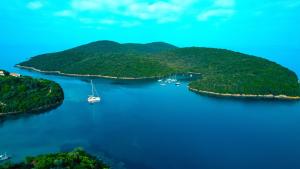 an island in the water with a boat in it at Home Sweet Home Unique Sea View in Sivota