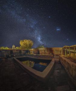 un cielo estrellado con una piscina por la noche en Terrantai Lodge en San Pedro de Atacama