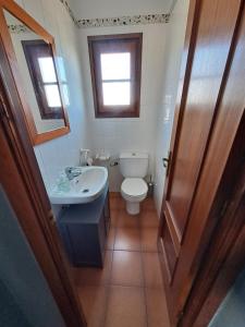 een badkamer met een toilet, een wastafel en een raam bij Casa apareada cerca de la playa in Torredembarra
