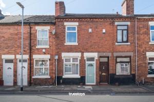 NEW Lime House by Truestays - 3 Bedroom House in Stoke-on-Trent في ستوك أون ترينت: مبنى من الطوب بأبواب بيضاء ونوافذ