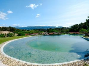 a large pool of water with mountains in the background at Lavandeira Douro Nature & Wellness in Baião