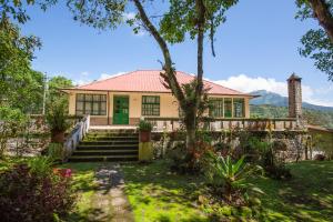 a house with a red roof and a green door at Niebli Historical Farm and Lodge at Pululahua Volcano in Quito