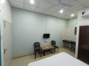 a waiting room with a table and chairs and a tv at The Corner Inn (Lodge) in Guwahati