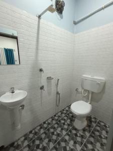 łazienka z toaletą i umywalką w obiekcie The Corner Inn (Lodge) w mieście Guwahati