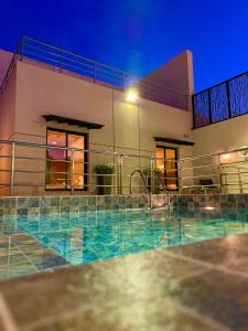a house with a swimming pool at night at شاليهات كابري وماديرا درة العروس in Durat Alarous +9 photos