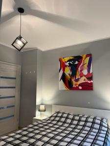 um quarto com uma cama e um quadro na parede em Cosy Apartment-Marine em Rumia