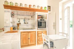 a kitchen with wooden cabinets and a stove top oven at Bastide les Oréades - Villa de luxe in Marseille