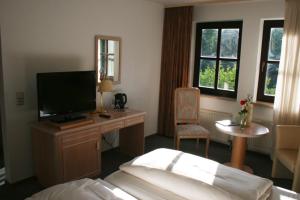 A bed or beds in a room at Landhotel Burkartsmühle
