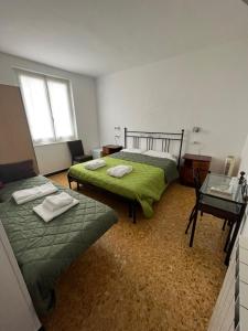 a bedroom with two beds and a table with a table at YOLO Rooms in Bonassola