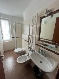 a bathroom with a sink and a toilet and a mirror at YOLO Rooms in Bonassola