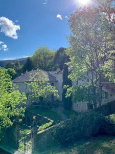 Elle offre une vue sur une maison avec un jardin. dans l'établissement Gîte Pommier au Château des Pauses, à Saint-André-de-Majencoules