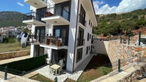 un edificio blanco con balcones en un lateral en Ozy Apart Garden / Kaş-Çerçiler, en Kas