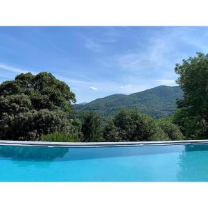 - une piscine avec vue sur les montagnes dans l'établissement Gîte Pommier au Château des Pauses, à Saint-André-de-Majencoules