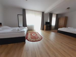 a large bedroom with two beds and a wooden floor at Vila Maria Bran in Şimon
