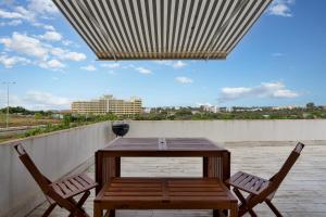 a wooden table and two chairs on a patio at Praia do Amado Flat by LovelyStay in Portimão