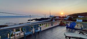 a balcony with chairs and a view of the ocean at Casa do Museu Marítimo in Santo Amaro