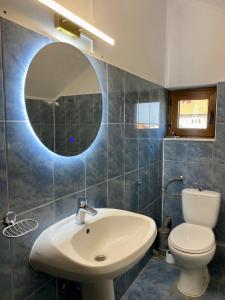 a bathroom with a sink and a toilet and a mirror at Apartament Central in Constanţa