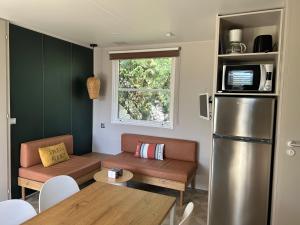 mały salon z kanapą i lodówką w obiekcie Mobil home PREMIUM 35m2 3 chambres 6 personnes w mieście Arès