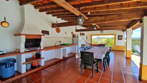 cocina y comedor con mesa y sillas en Castelo de Bode Monte do Valinho Country house with private pool and panoramic views, en Alverangel
