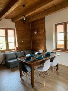 salon z drewnianym stołem i krzesłami w obiekcie Osada na Granicy - Domki w Bieszczadach w mieście Ustrzyki Dolne