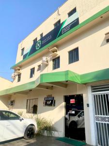 a white car parked in front of a building at Hotel Mendes Azevedo in Goiânia