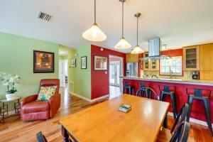 a kitchen and living room with a wooden table and chairs at St Augustine Vacation Rental with Private Hot Tub! in Saint Augustine