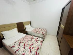 two beds in a hotel room with at Al Rakaez Tourist Hostel in Al Hada