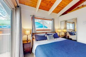 a bedroom with a blue bed and a window at Saddle Road Sanctuary in South Lake Tahoe