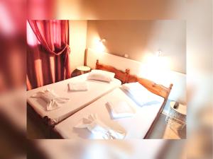 two beds in a room with a red curtain at Le stanze del tramonto di Eleni in Leipsoi