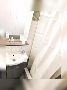 bagno con lavandino, servizi igienici e specchio di Le stanze del tramonto di Eleni a Lisso (Lipsoi)