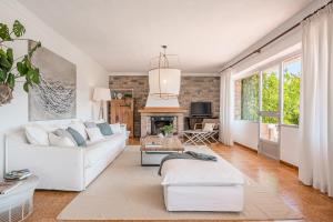 sala de estar con sofá blanco y chimenea en Villa Son Bibiloni, en Algaida