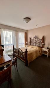 a large bedroom with a large bed and a table at Jaukūs Friedricho pasažo apartamentai in Klaipėda