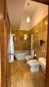 a bathroom with two toilets and a tub and two sinks at Jaukūs Friedricho pasažo apartamentai in Klaipėda +14 photos
