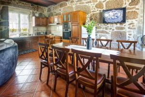 uma cozinha com mesa e cadeiras num quarto em Quinta das Oliveiras em Arcos de Valdevez