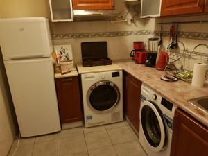 a kitchen with a refrigerator and a washing machine at LA CASA in Tbilisi City