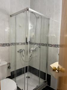 a glass shower in a bathroom with a toilet at Real Caparica Hotel in Costa da Caparica